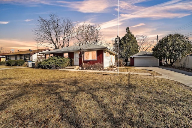 single story home featuring a garage, a yard, and an outbuilding