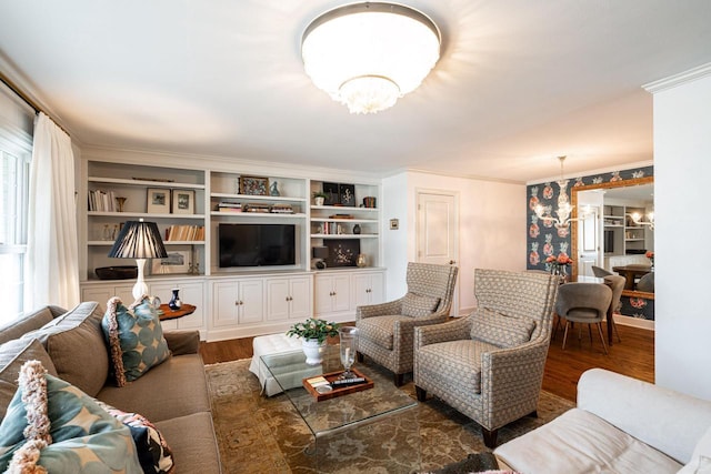 living room featuring an inviting chandelier, ornamental molding, and dark hardwood / wood-style floors