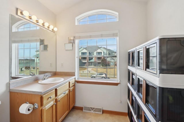 bathroom featuring vanity, baseboards, visible vents, and tile patterned flooring