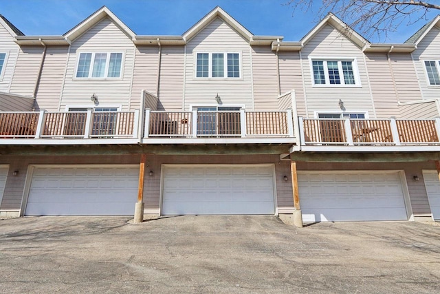 rear view of property with an attached garage and driveway