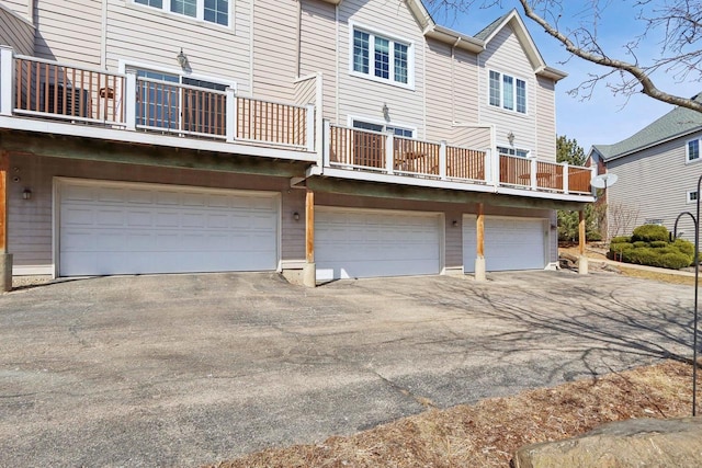 rear view of property featuring aphalt driveway and a garage