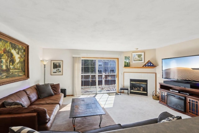 carpeted living area with a tiled fireplace