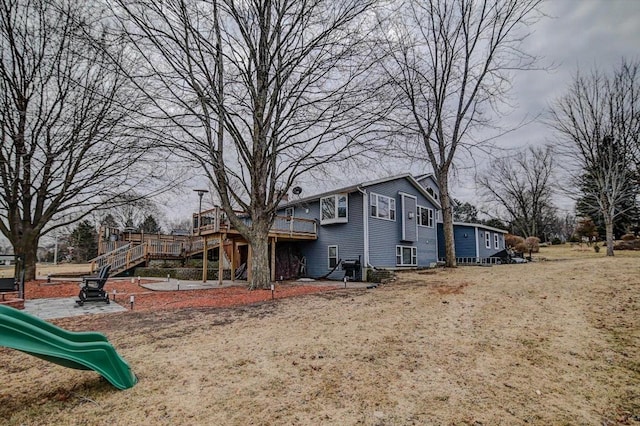 back of property featuring a lawn and a playground