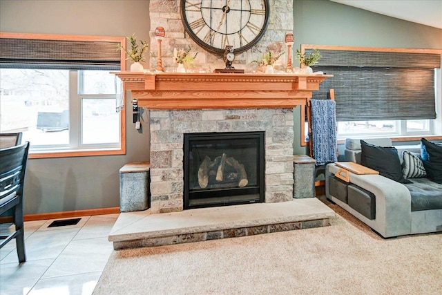 tiled living room with a fireplace, vaulted ceiling, and a wealth of natural light