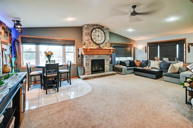 carpeted living room with ceiling fan, a fireplace, and vaulted ceiling