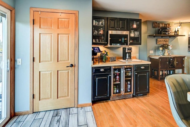 bar featuring wine cooler and light wood-type flooring