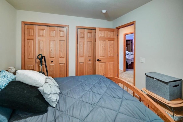 bedroom with carpet and two closets