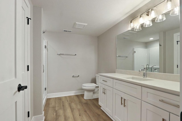 4675 98th St, Pleasant Prairie, WI 53158 - full bath featuring vanity, a stall shower, toilet, wood finished floors, and baseboards