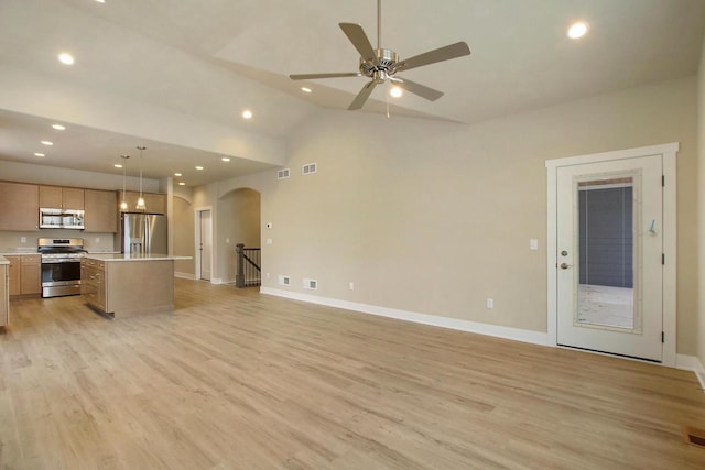 unfurnished living room featuring ceiling fan, vaulted ceiling, and light hardwood / wood-style flooring