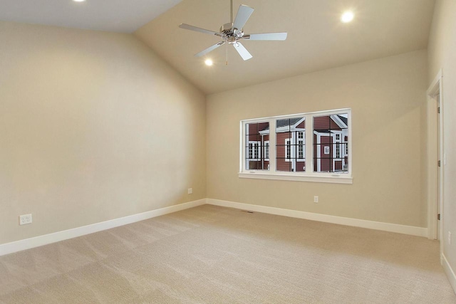 carpeted spare room with vaulted ceiling and ceiling fan