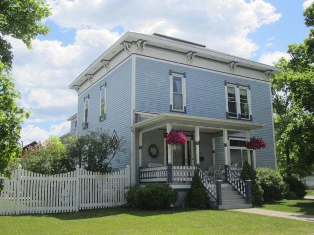 italianate home with a front yard and covered porch