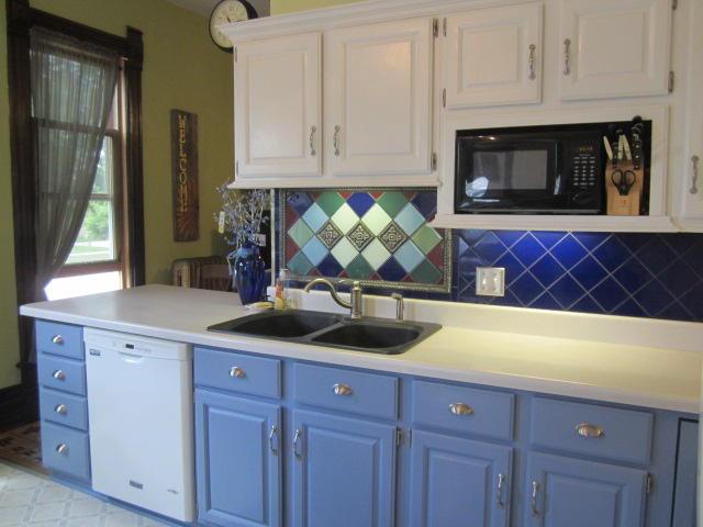 kitchen with tasteful backsplash, sink, white cabinets, and white dishwasher