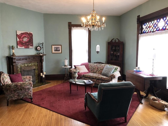 living room featuring a tile fireplace, hardwood / wood-style floors, and a notable chandelier