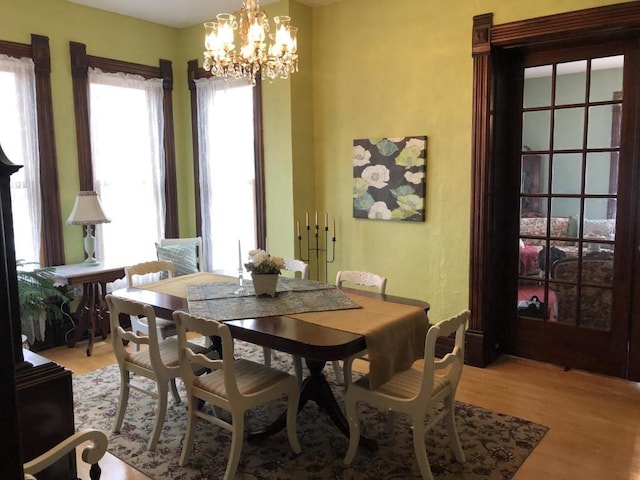 dining space with a notable chandelier and light wood-type flooring