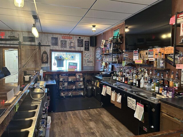 59460 Main St, Mason, WI 54856 - bar with dark wood-type flooring, a barn door, and a paneled ceiling