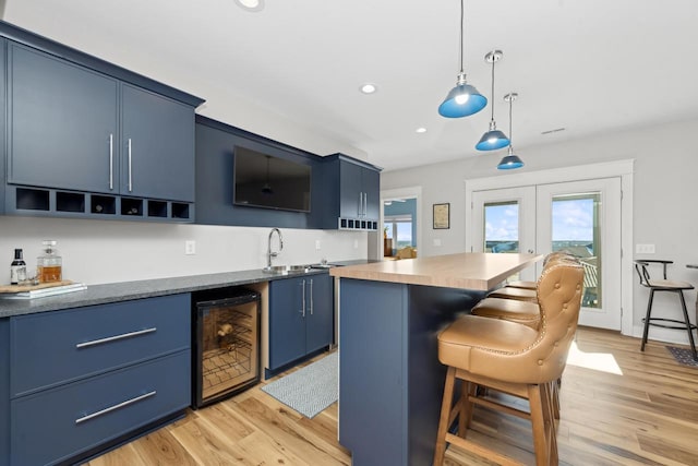 kitchen with wine cooler, blue cabinetry, french doors, and a kitchen island