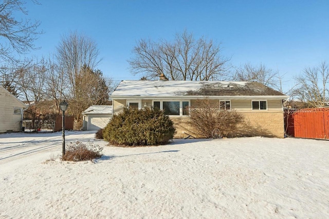 view of snow covered exterior featuring a garage and an outdoor structure