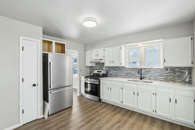 kitchen featuring stainless steel appliances, sink, white cabinets, and backsplash