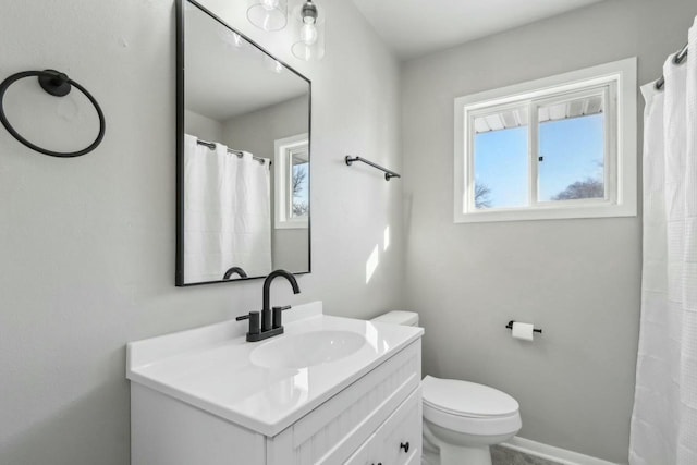 bathroom featuring vanity, a healthy amount of sunlight, and toilet