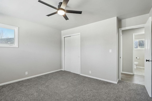 unfurnished bedroom featuring ceiling fan, dark carpet, and a closet