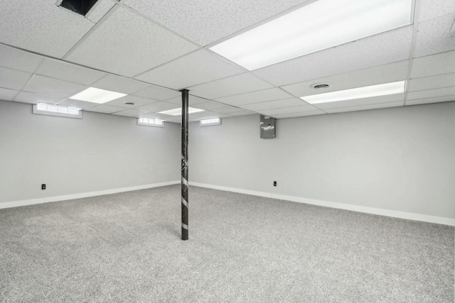 basement with a drop ceiling and carpet