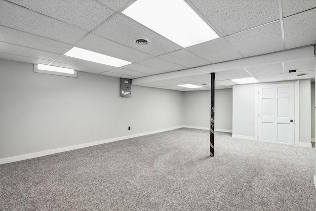 basement featuring a paneled ceiling and carpet