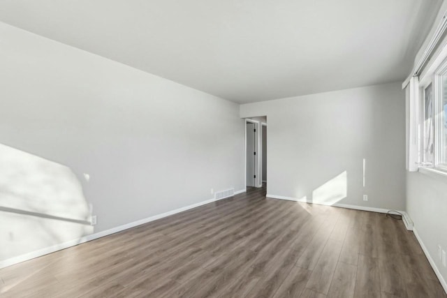 unfurnished room with dark wood-type flooring