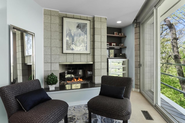 living area with a tile fireplace