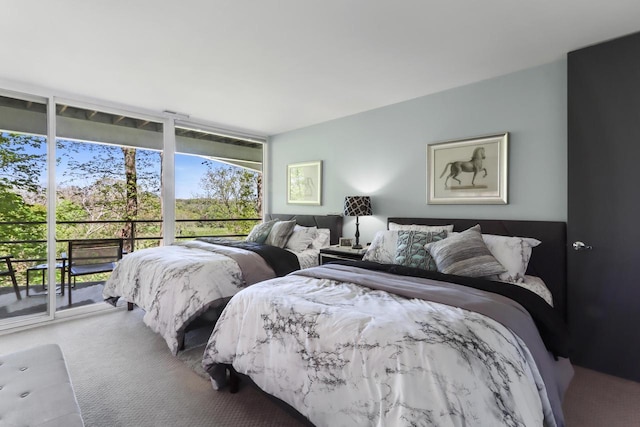 bedroom featuring expansive windows, access to exterior, and carpet