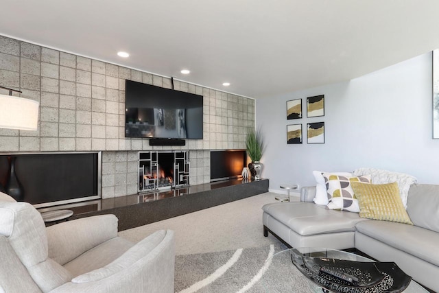 living room with a tiled fireplace and carpet