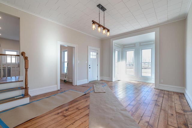 entryway with crown molding and light wood-type flooring