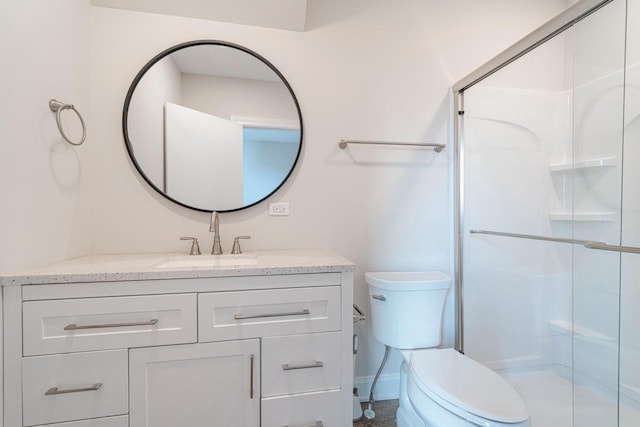 bathroom featuring vanity, a shower with shower door, and toilet