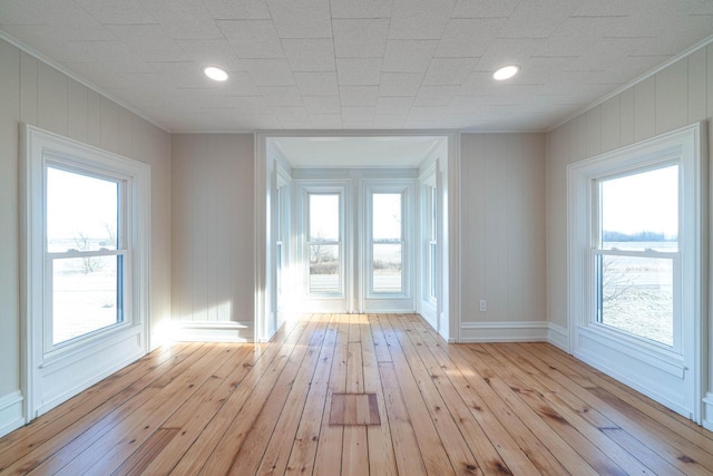 doorway to outside with ornamental molding and light hardwood / wood-style floors