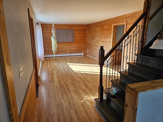 interior space featuring baseboard heating, wooden walls, and hardwood / wood-style flooring