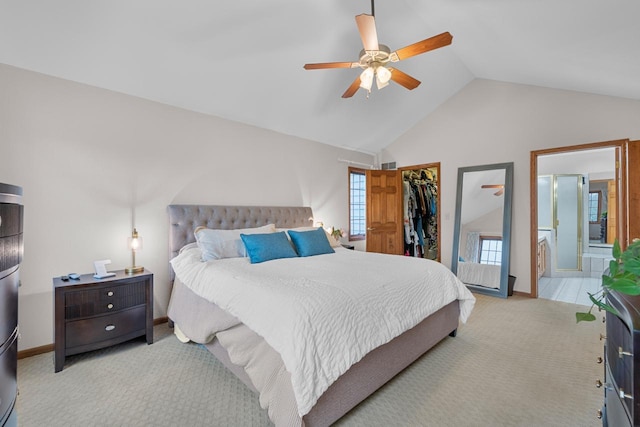 carpeted bedroom featuring ensuite bathroom, a walk in closet, vaulted ceiling, a closet, and ceiling fan