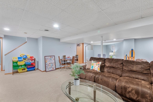 living room with a paneled ceiling and carpet