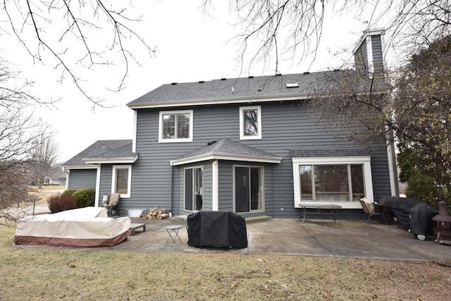 rear view of house with a lawn and a patio area