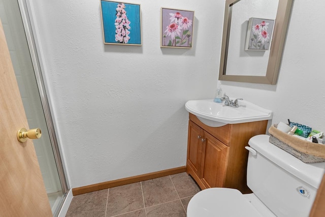 bathroom with tile patterned flooring, vanity, walk in shower, and toilet