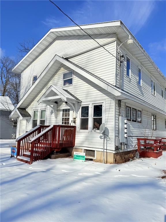 view of snow covered back of property