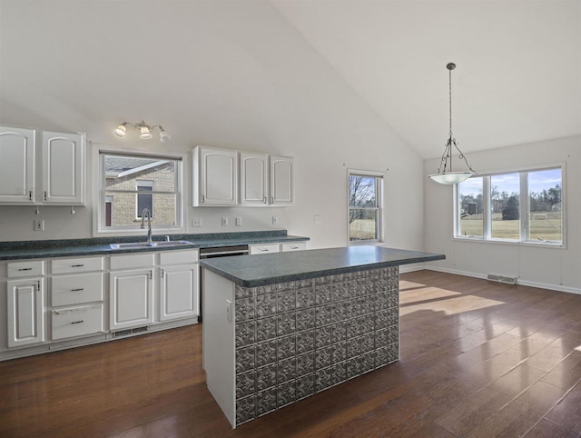 kitchen featuring white cabinetry, sink, pendant lighting, and a center island