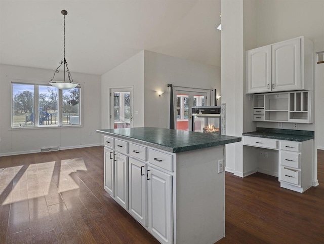 kitchen featuring a kitchen island, dark hardwood / wood-style floors, white cabinets, and decorative light fixtures