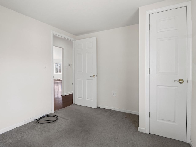 unfurnished bedroom with dark colored carpet