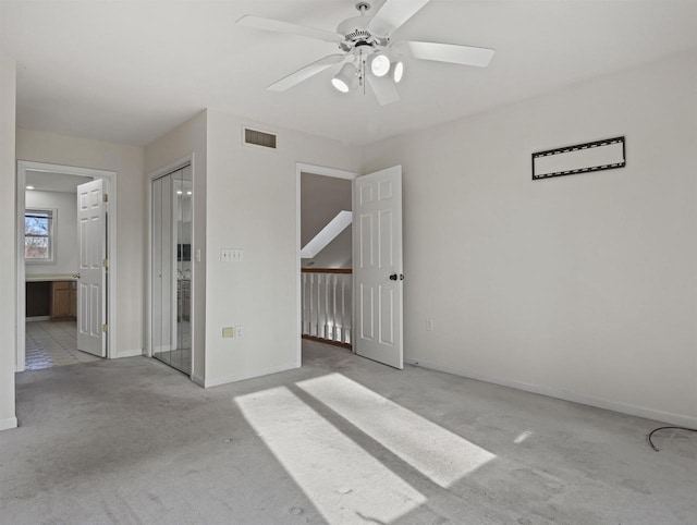 carpeted spare room with ceiling fan