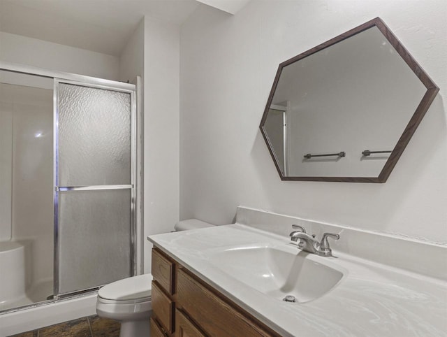 bathroom with a shower with door, vanity, and toilet