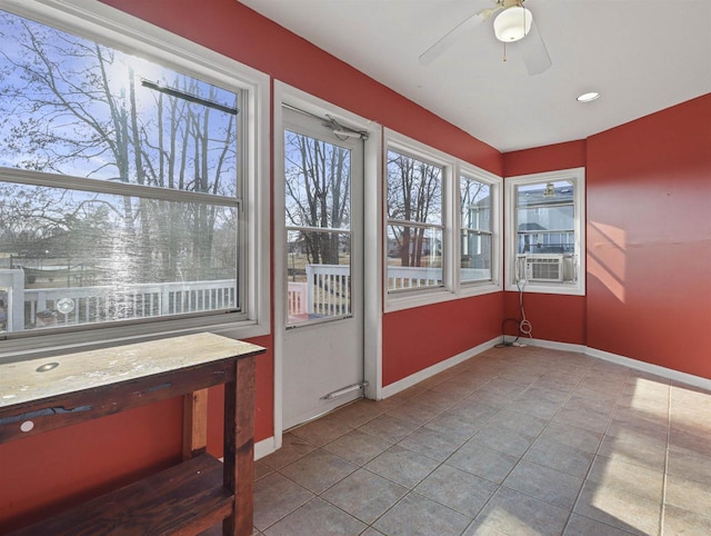 unfurnished sunroom with cooling unit and ceiling fan