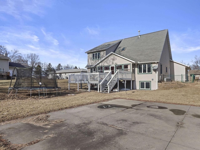 rear view of property with a patio, a deck, and a trampoline