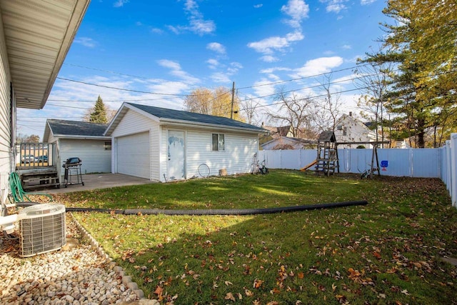 view of yard featuring an outbuilding, a garage, a playground, and central air condition unit