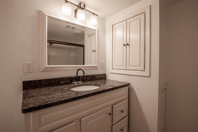 bathroom featuring vanity and an enclosed shower