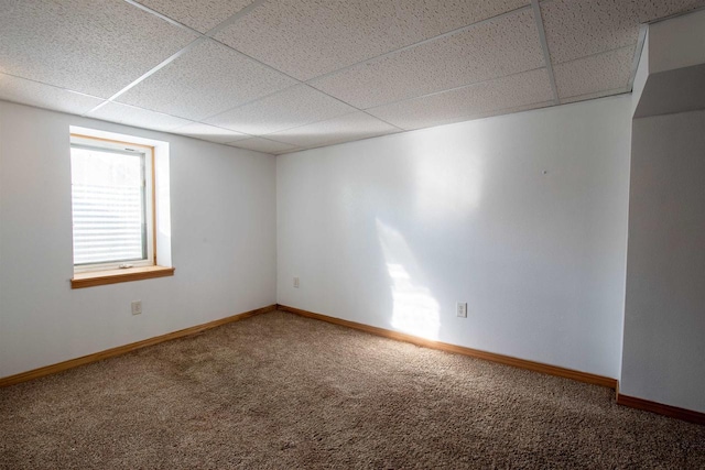 unfurnished room featuring a paneled ceiling and carpet