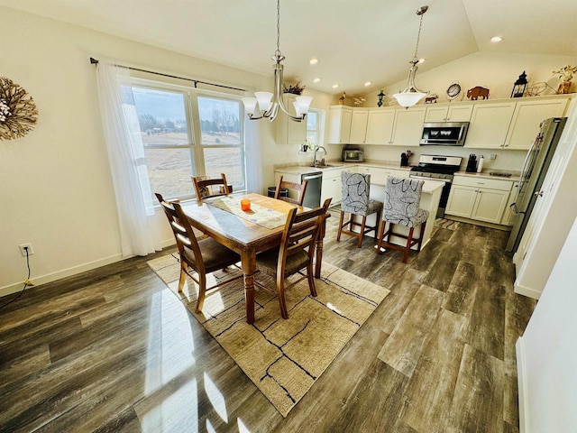 dining area with lofted ceiling, dark hardwood / wood-style floors, sink, and an inviting chandelier